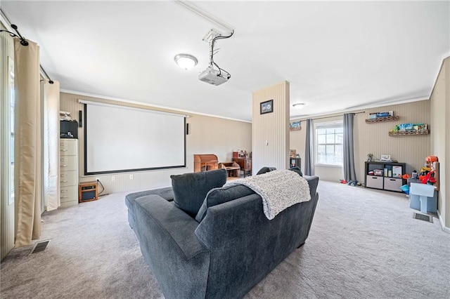 home theater with carpet floors, ornamental molding, and visible vents