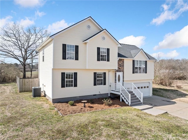 split level home with a front yard, central AC unit, a garage, crawl space, and driveway