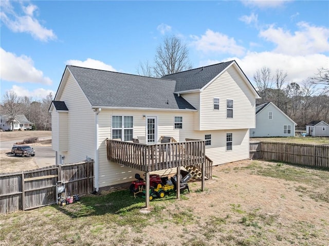 back of house with a yard, roof with shingles, fence private yard, and a wooden deck