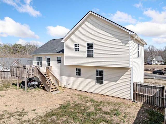 rear view of property featuring stairs, fence, and a wooden deck