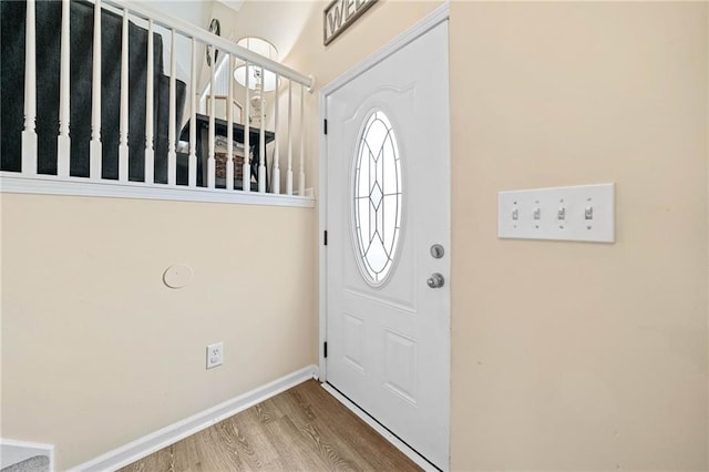 foyer with stairs, baseboards, and wood finished floors