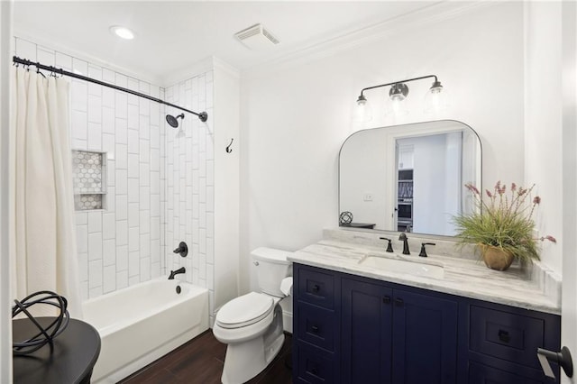 bathroom featuring toilet, visible vents, wood finished floors, crown molding, and vanity