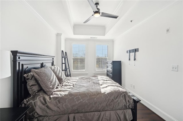 bedroom with dark wood finished floors, baseboards, ceiling fan, crown molding, and a raised ceiling