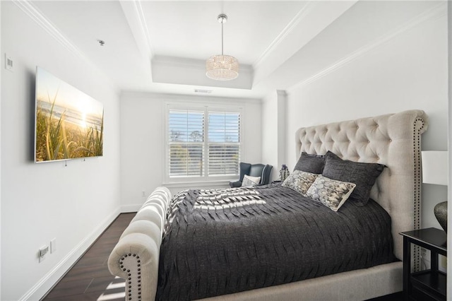 bedroom featuring a raised ceiling, baseboards, dark wood-style floors, and ornamental molding