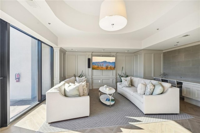 living room featuring visible vents and a decorative wall
