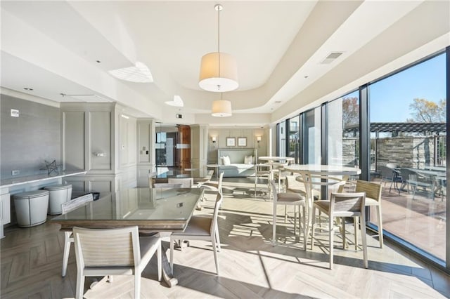 dining room with visible vents and a raised ceiling