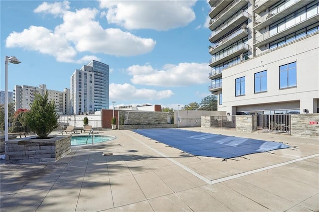 community pool featuring fence and a patio area