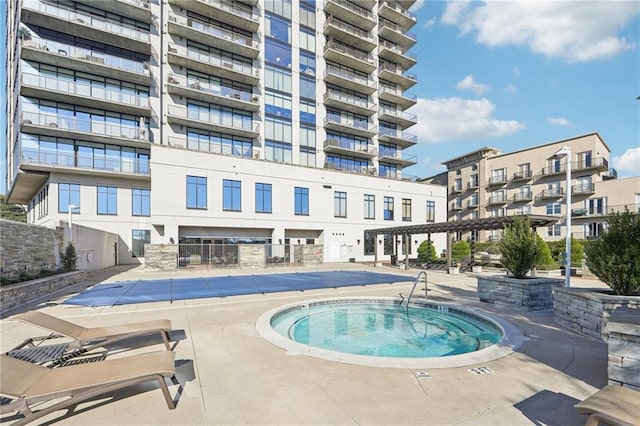 view of swimming pool with a community hot tub