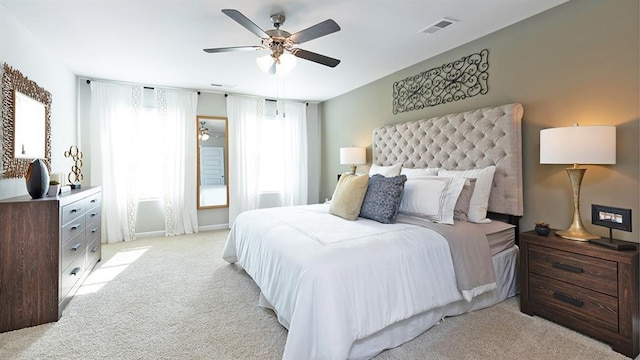 bedroom featuring light carpet, visible vents, and a ceiling fan