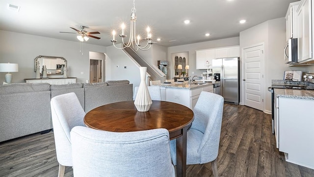 dining room featuring ceiling fan with notable chandelier, dark wood finished floors, visible vents, and recessed lighting