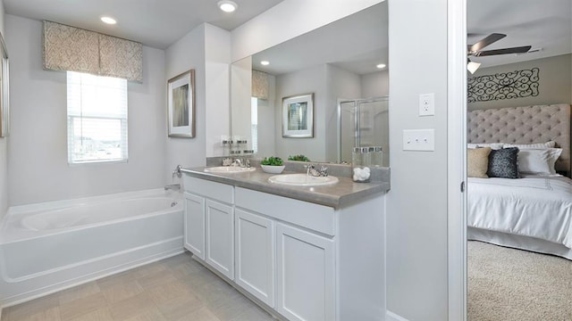 ensuite bathroom featuring a garden tub, ensuite bath, a sink, and a shower stall