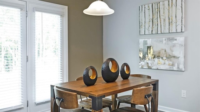 dining space featuring plenty of natural light and baseboards