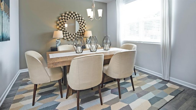 dining area featuring an inviting chandelier, wood finished floors, and baseboards