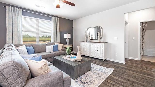 living room with ceiling fan, wood finished floors, visible vents, and baseboards