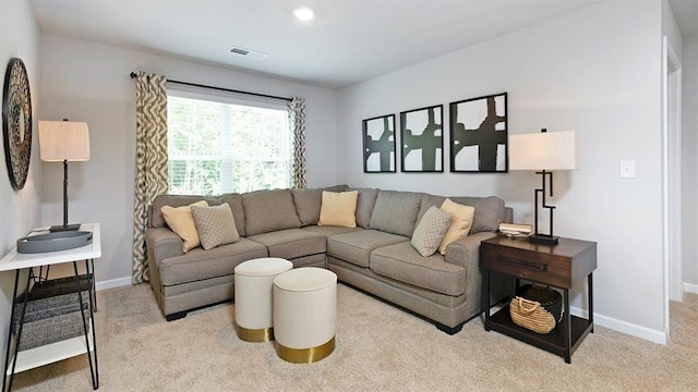 carpeted living area featuring visible vents and baseboards