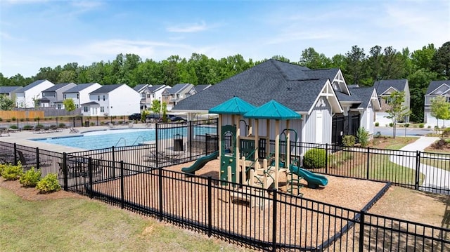 communal playground with fence, a residential view, and a community pool