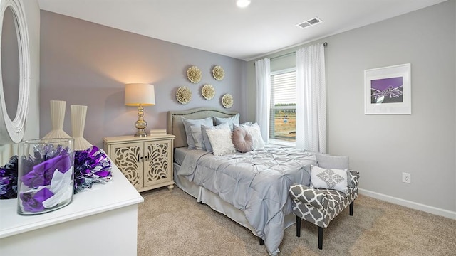 carpeted bedroom with visible vents and baseboards