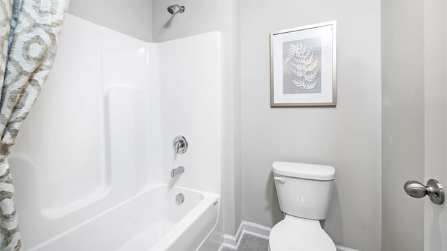 full bathroom featuring tub / shower combination, toilet, and baseboards