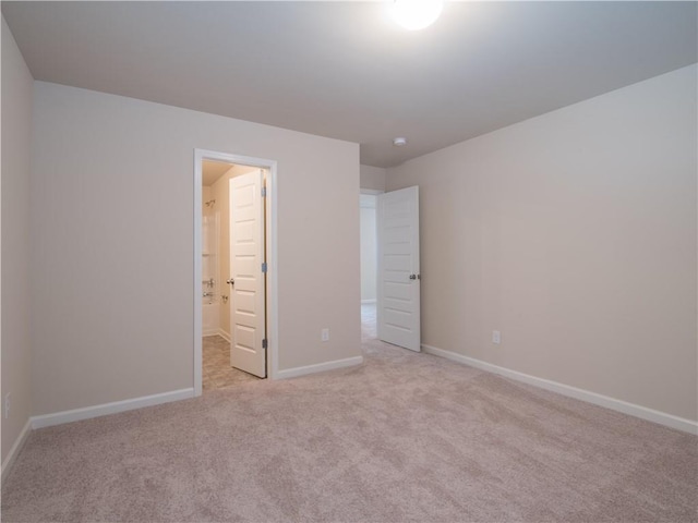 unfurnished bedroom featuring light colored carpet and baseboards