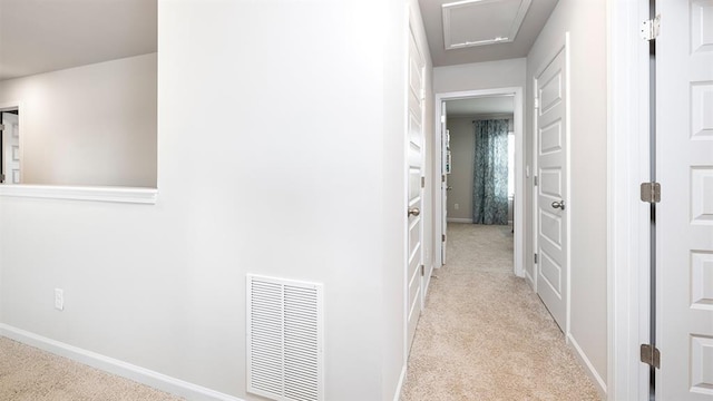 hall featuring carpet floors, visible vents, and baseboards