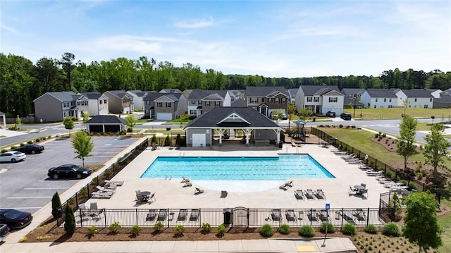 view of swimming pool featuring a residential view, fence, and a gazebo