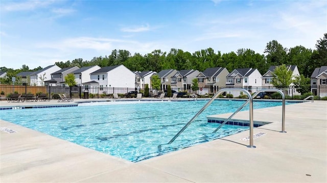 pool featuring a residential view, a patio area, and fence