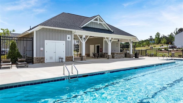 community pool with ceiling fan, fence, an exterior structure, a patio area, and an outdoor structure