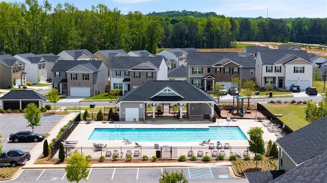 pool featuring a patio, fence, and a residential view