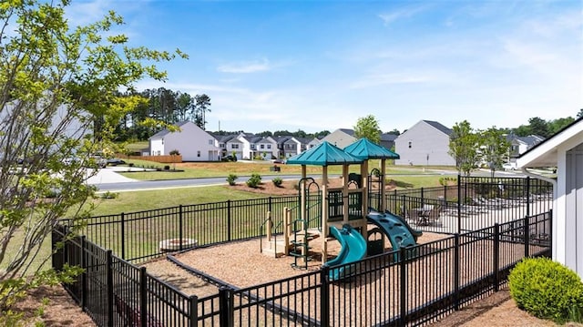 communal playground with a lawn, fence, and a residential view