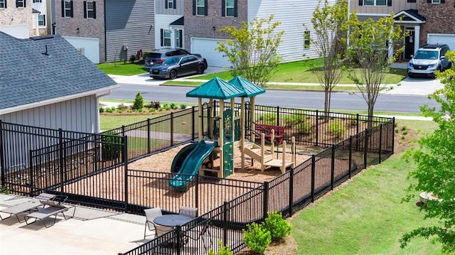 community play area featuring fence and a residential view