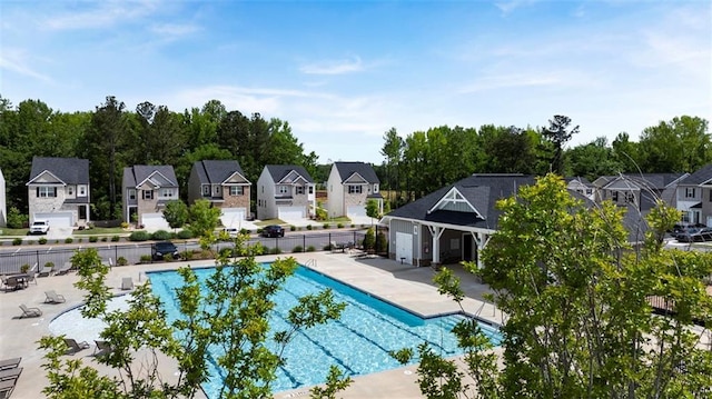 pool with a residential view, fence, and a patio