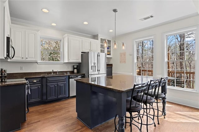 7105 Haw Crk, Gainesville, GA 30506 - kitchen with light wood finished floors, appliances with stainless steel finishes, a breakfast bar area, and a sink