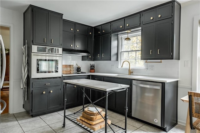 kitchen featuring tasteful backsplash, sink, light tile patterned floors, and stainless steel appliances