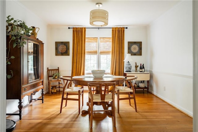 dining area featuring crown molding and light hardwood / wood-style flooring