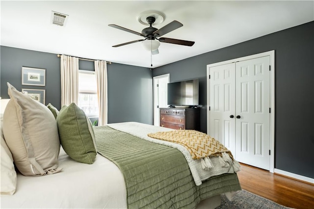 bedroom featuring hardwood / wood-style floors, ceiling fan, and a closet