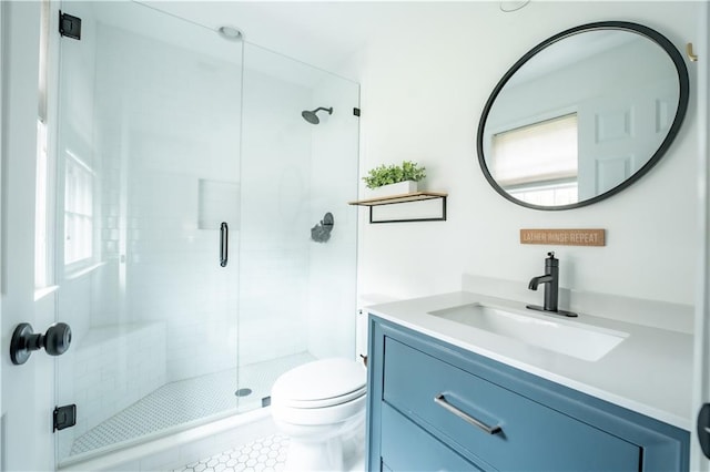 bathroom with vanity, a healthy amount of sunlight, toilet, and a shower with shower door