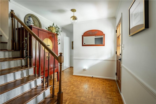 staircase featuring parquet flooring and crown molding