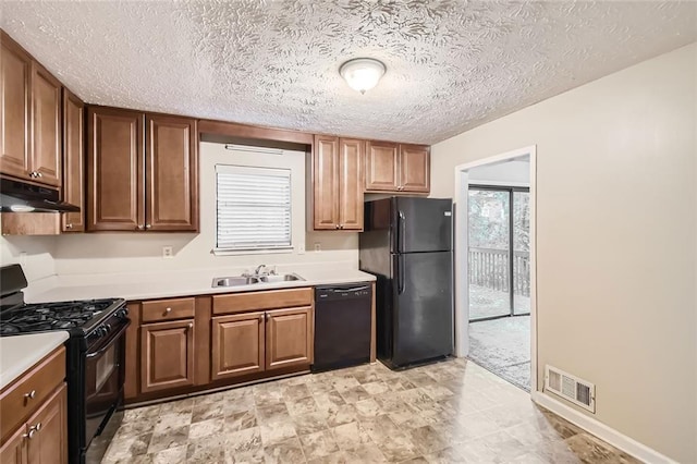 kitchen with a textured ceiling, black appliances, and sink