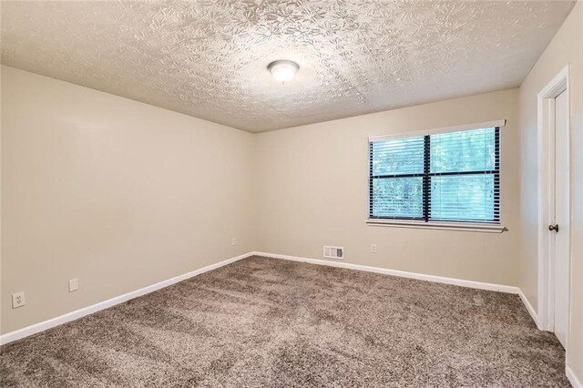 carpeted spare room with a textured ceiling