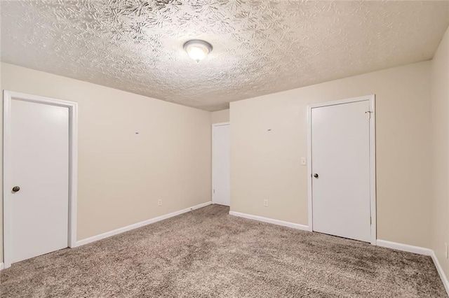 carpeted spare room with a textured ceiling