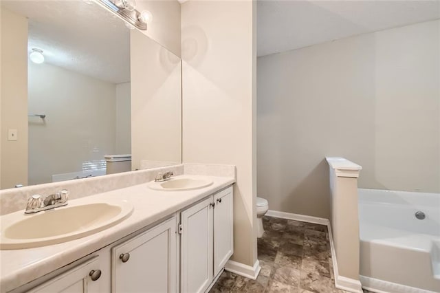 bathroom featuring a tub to relax in, toilet, and vanity