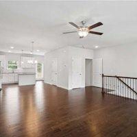 unfurnished living room featuring ceiling fan and dark wood-type flooring