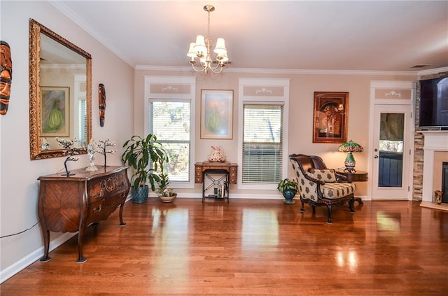 sitting room featuring hardwood / wood-style flooring, crown molding, and a notable chandelier