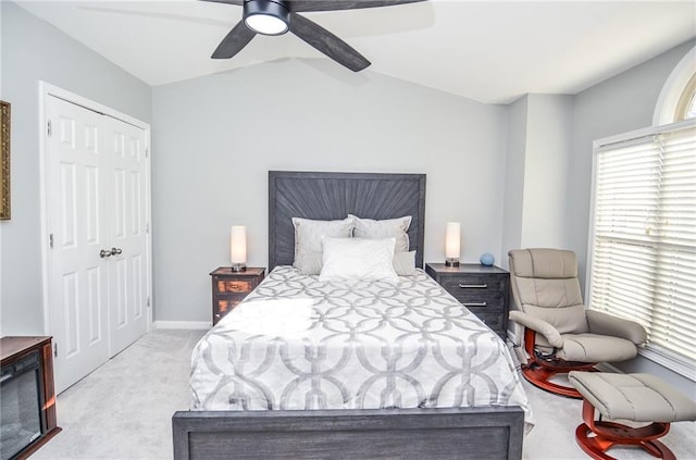 carpeted bedroom with vaulted ceiling, a closet, and ceiling fan