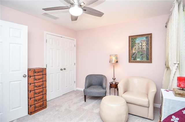 living area with ceiling fan and light colored carpet