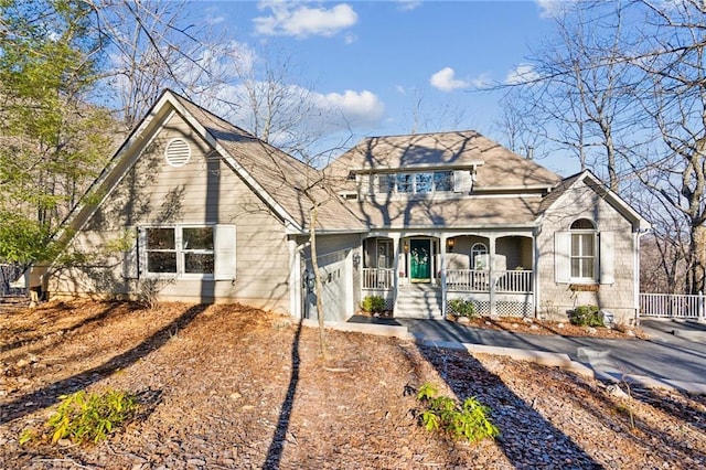 view of front facade with a porch, a garage, and driveway