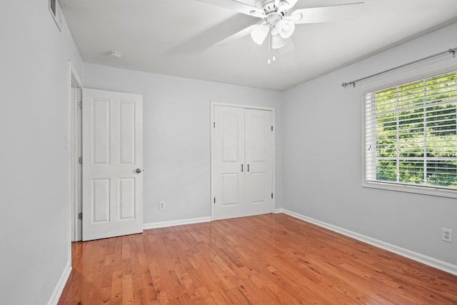 unfurnished bedroom with ceiling fan, a closet, and light hardwood / wood-style floors