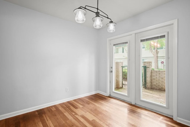 doorway with an inviting chandelier and hardwood / wood-style flooring