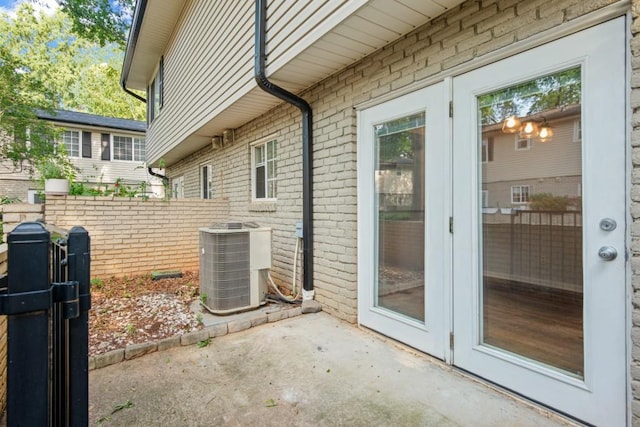 view of side of property with a patio area, french doors, and central AC unit