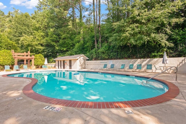 view of swimming pool featuring a patio area and an outdoor structure